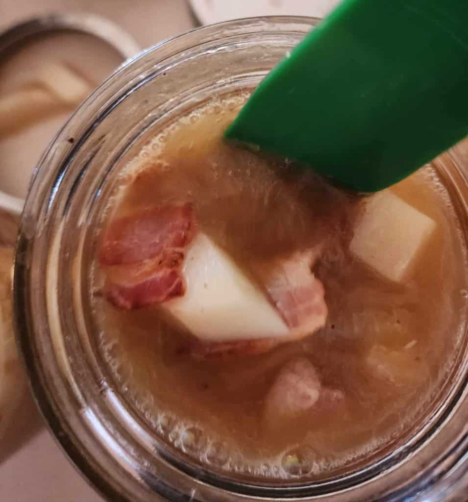 Removing air bubbles from the jar or loaded potato soup before canning