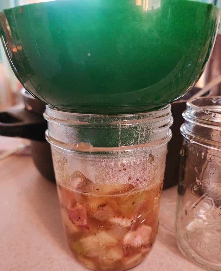 Adding loaded potato soup to canning jars using canning funnel