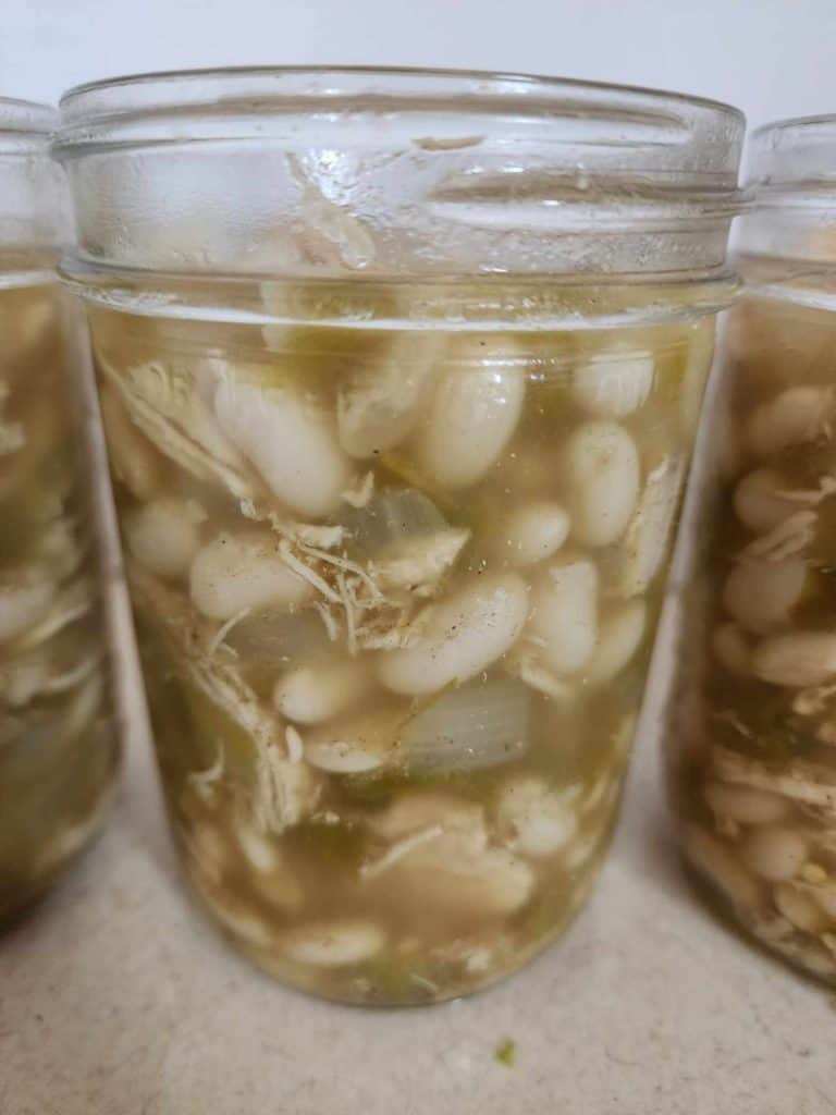 white chicken chili added to jar before canning
