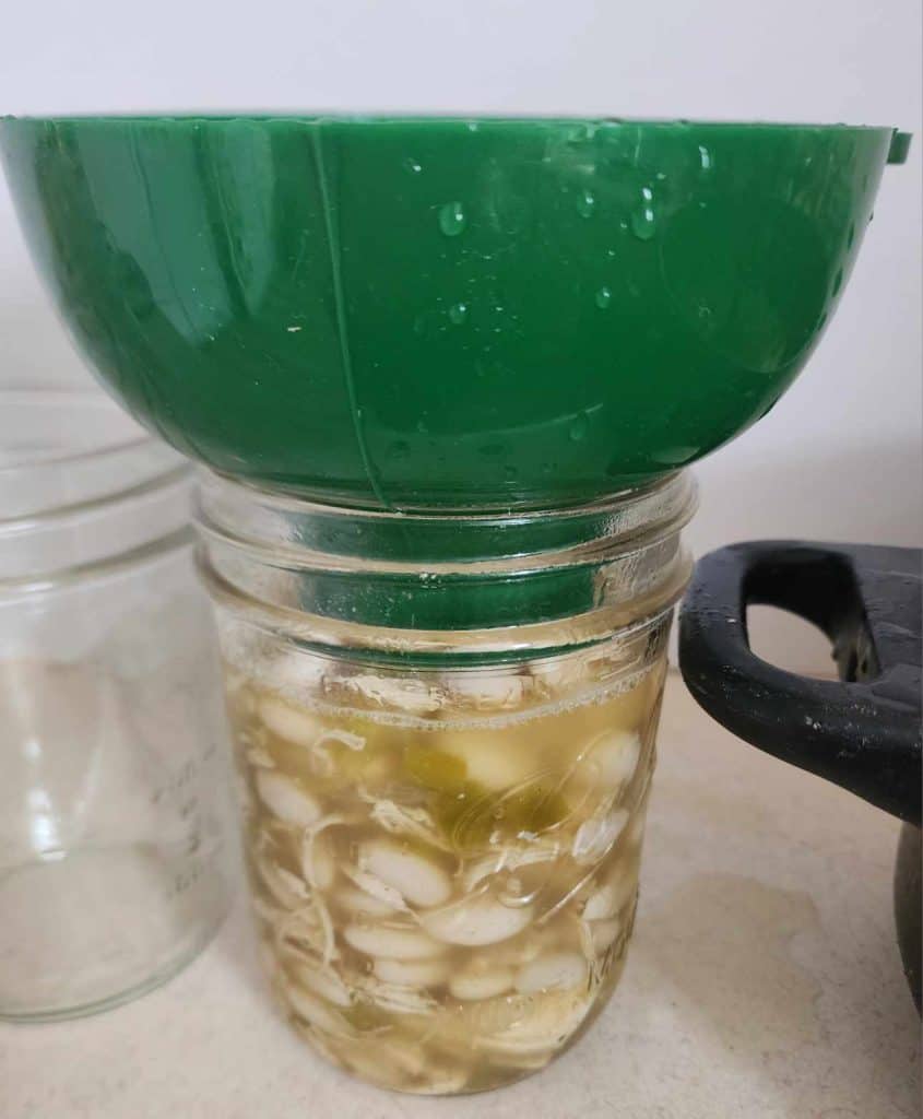 Adding white chicken chili to canning jar using a canning funnel