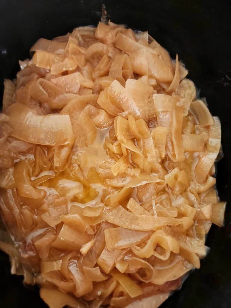 onions cooking in butter in a slow cooker until caramelized.