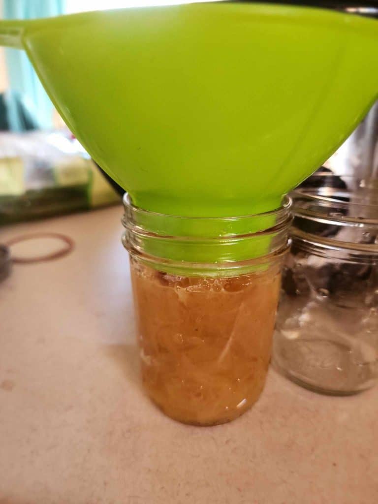 Filling jars with caramelized onions using a canning funnel
