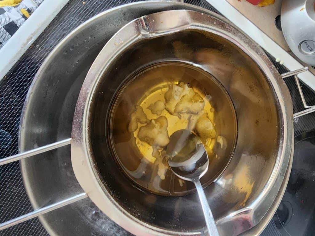 Stirring beeswax and shea butter to make rosemary lotion bars