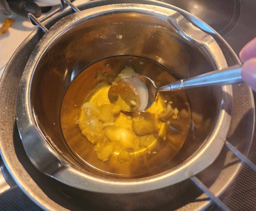 stirring the honeysuckle lotion bar infused oil and the shea butter and beeswax
