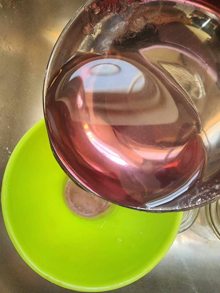 ladling violet jelly into jars