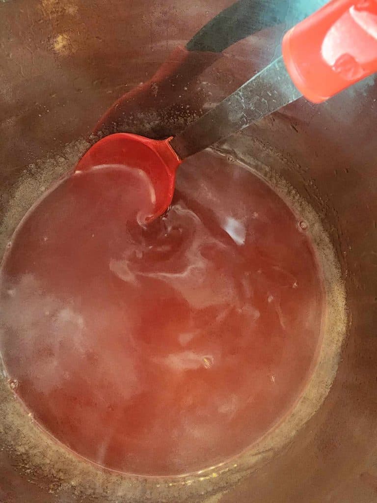 Adding pectin and sugar to violet jelly