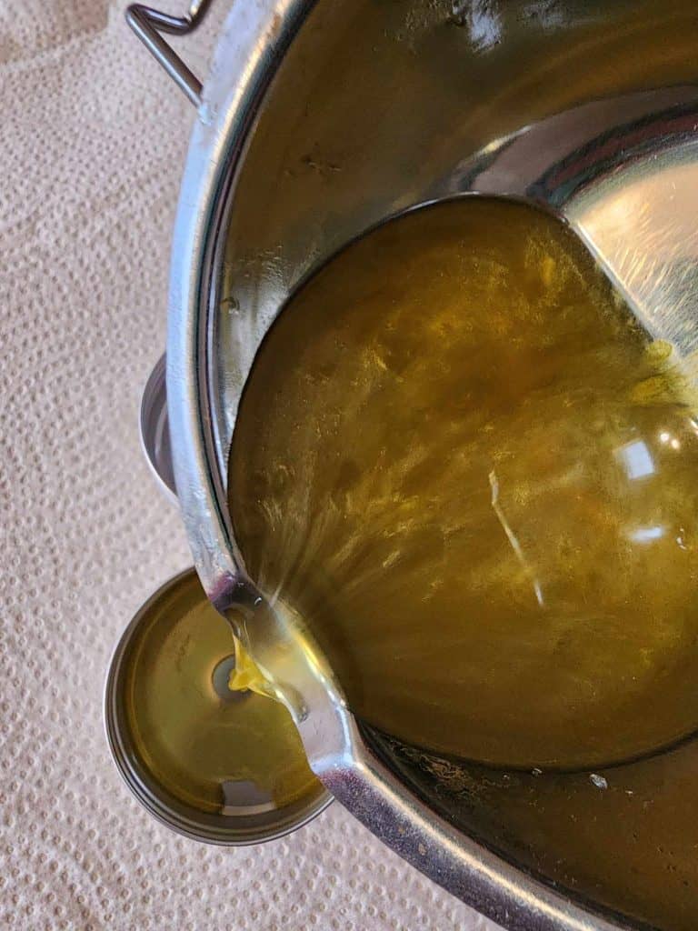 Pouring lemon balm salve into the tins