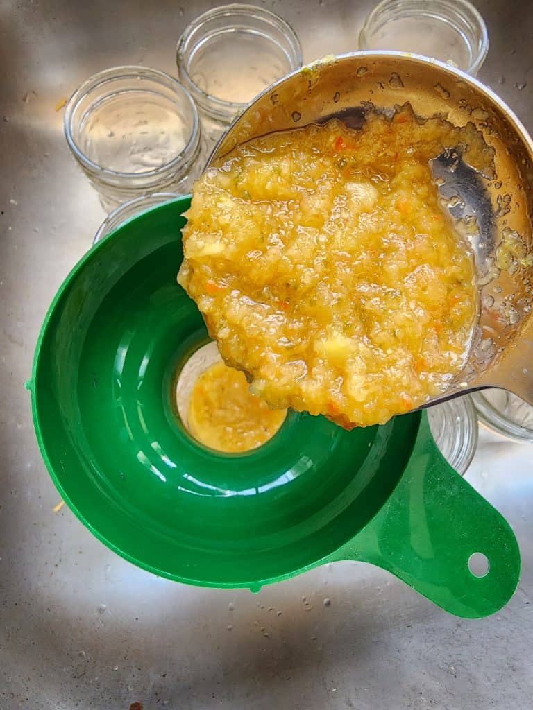 ladling the pineapple jalapeno bourbon bbq sauce into jars
