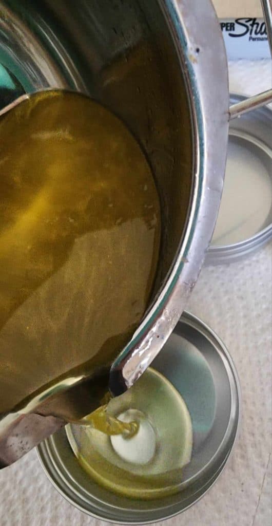 pouring calendula plantain salve into tins