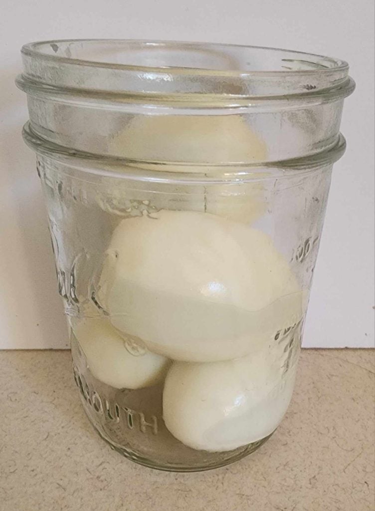 4 hard boiled eggs placed in pint jar for dill pickled egg recipe