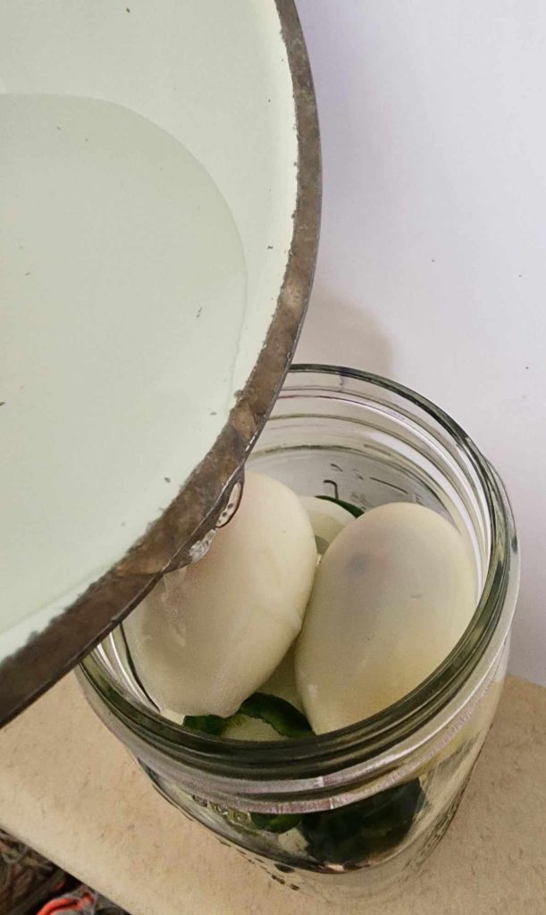 Pouring brine over the eggs to make jalapeno pickled eggs
