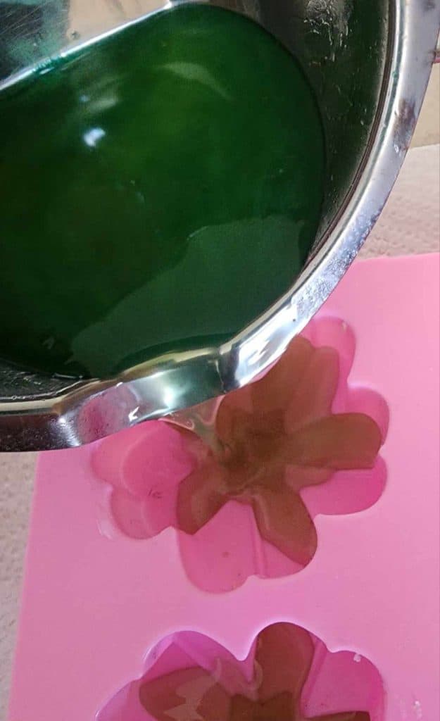 pouring sage and rosemary lotion bar mixture into molds