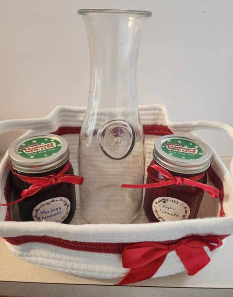 jars of lemonade concentrate in basket with pitcher