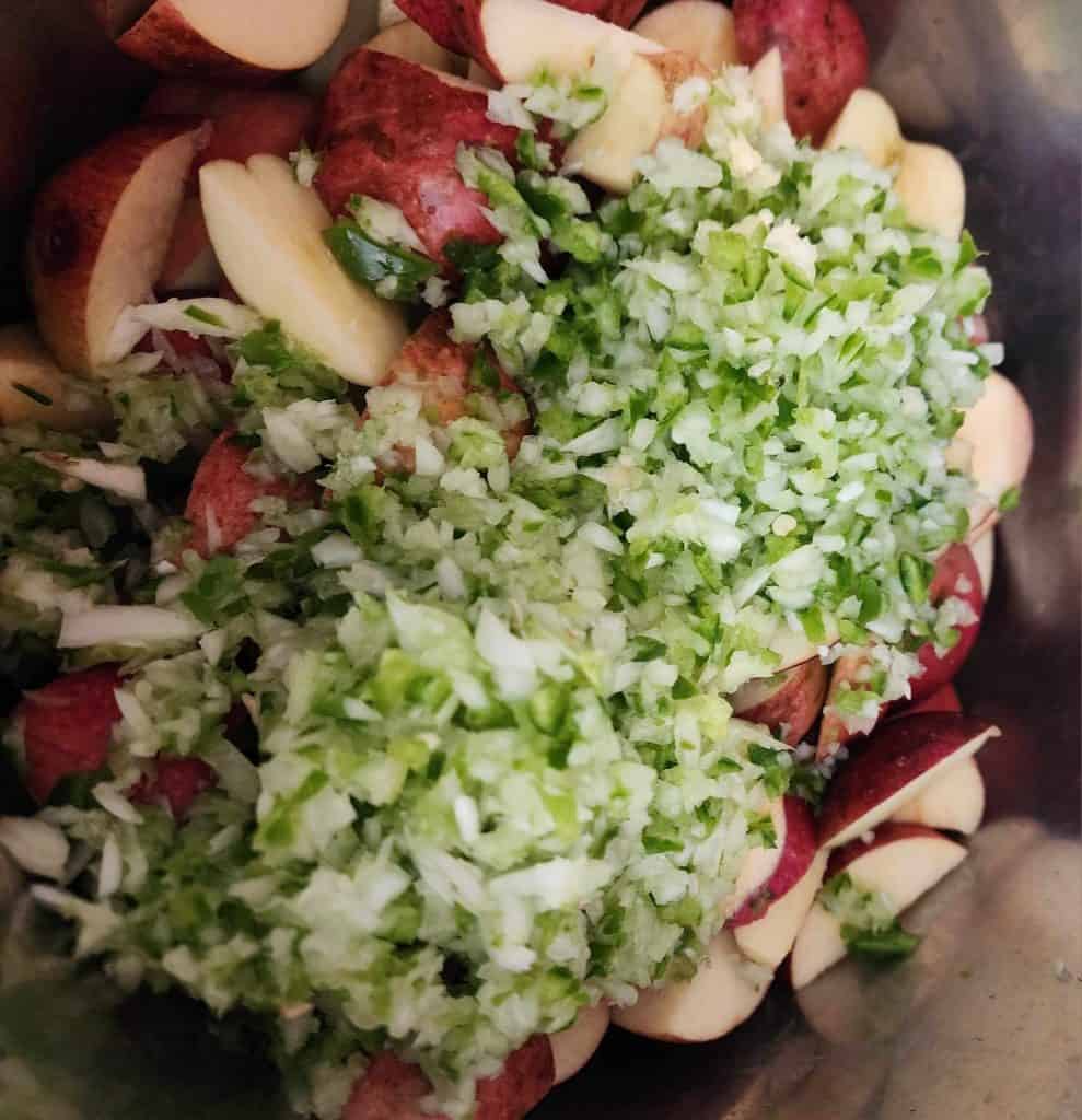 Adding the pepper and onions to the apples in the instant pot to make apple jalapeno bourbon bbq sauce