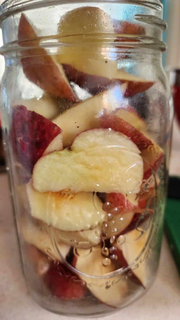Quart of cut up apples measuring them to make apple jalapeno bourbon bbq sauce