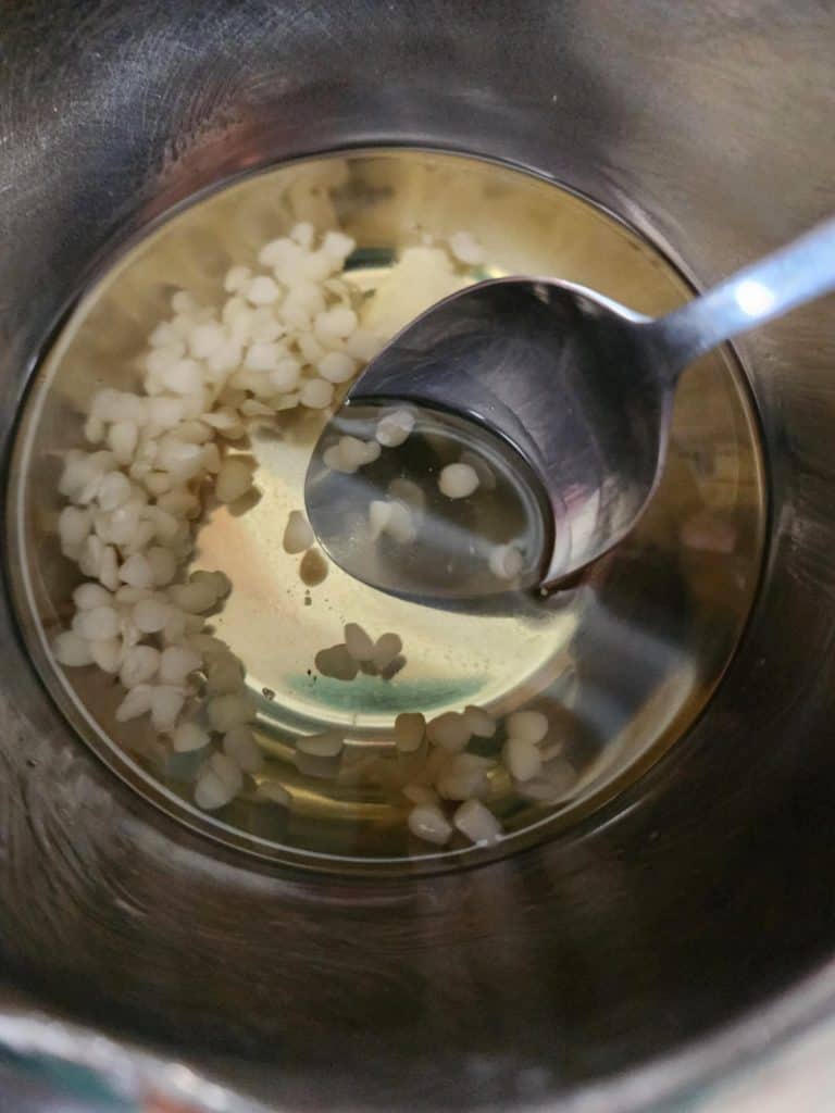 mixing shea butter and beeswax to make rose salve