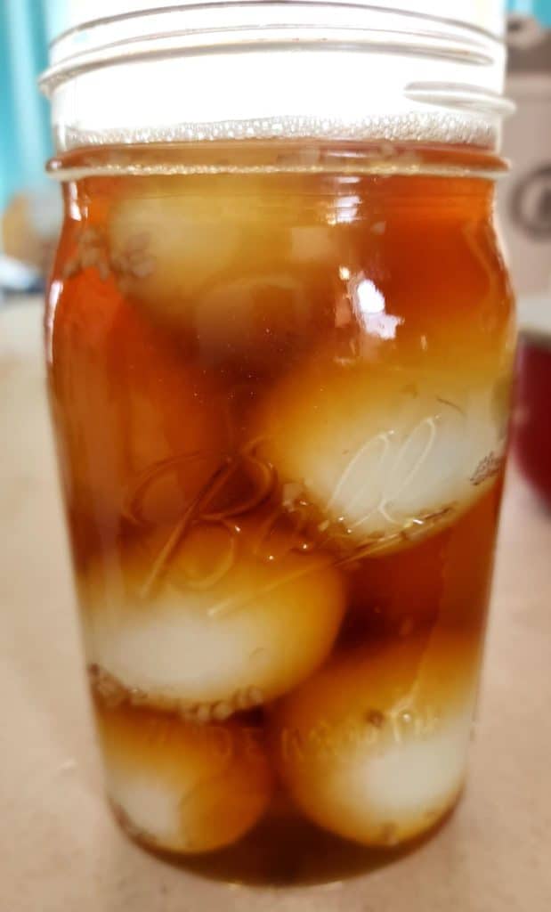 Smoky pickled eggs in a jar with brine