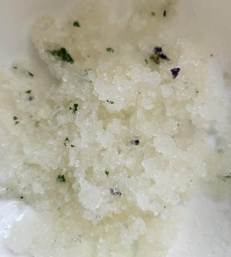 violet salt scrub ingredients mixed in a bowl