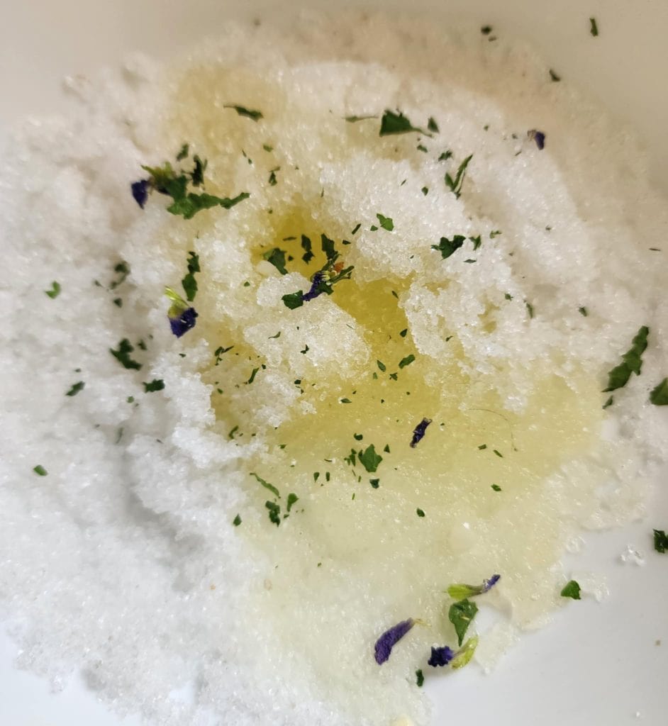 violet salt scrub ingredients added to bowl