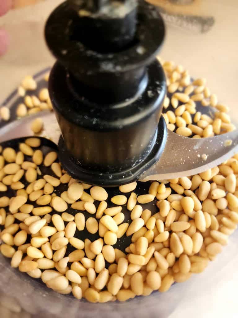 pine nuts in a food processor to make homemade basil pesto