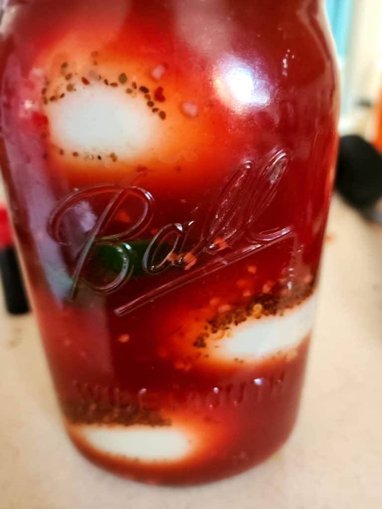 Brine poured into jars of eggs to make Bloody Mary Pickled eggs