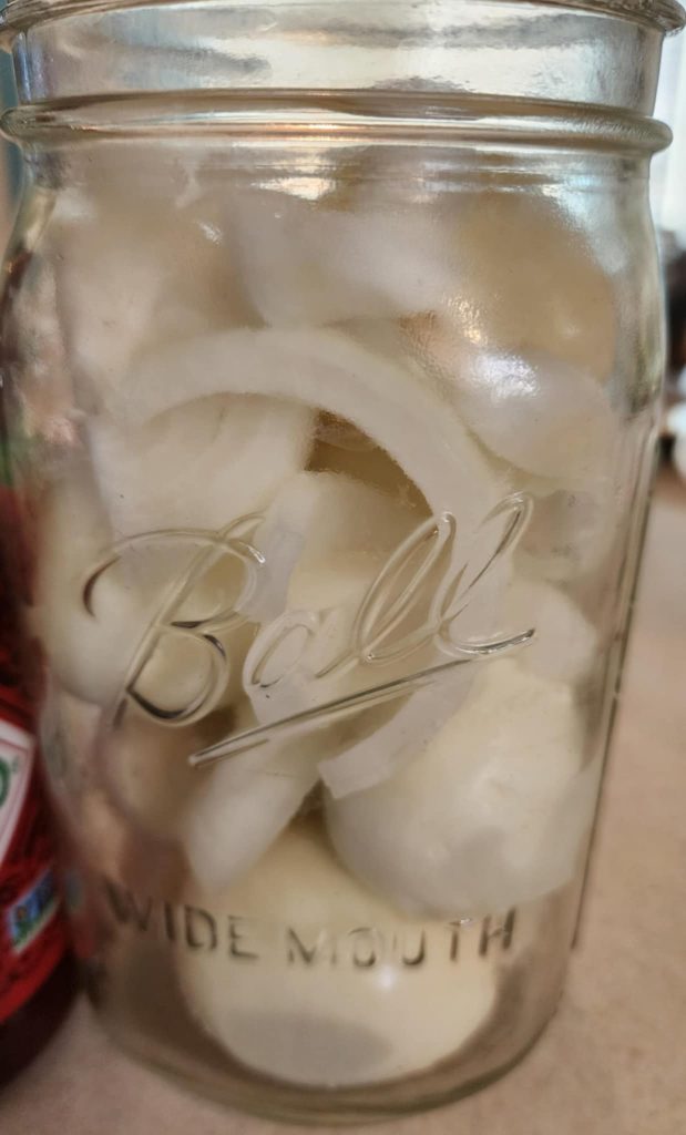 onions and eggs layered in a jar for sriracha pickled eggs