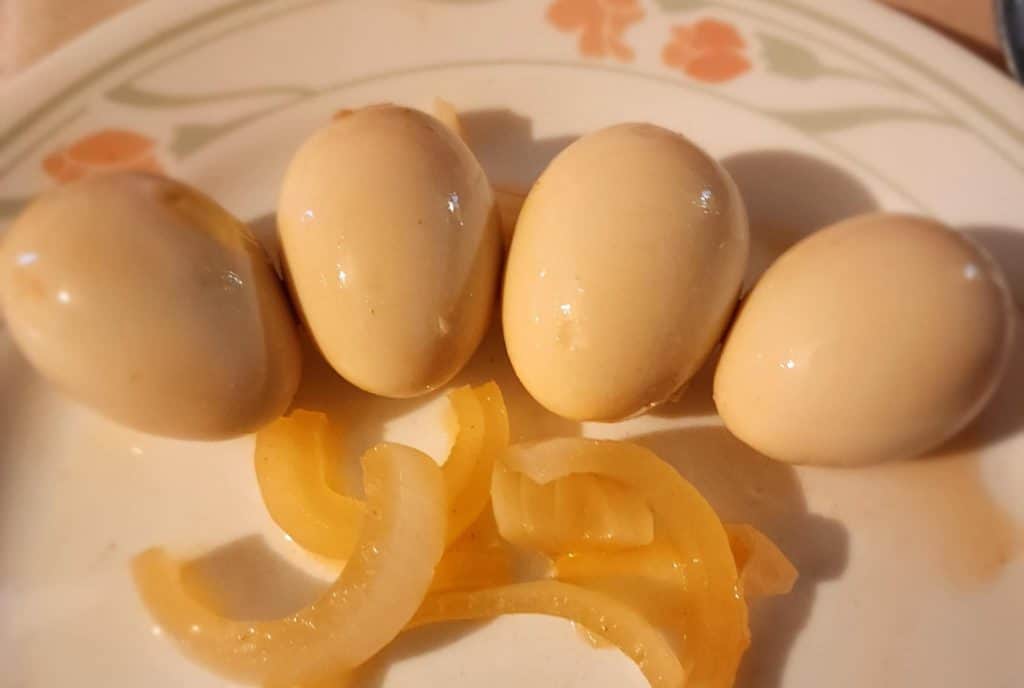 sriracha pickled eggs with onions on a plate