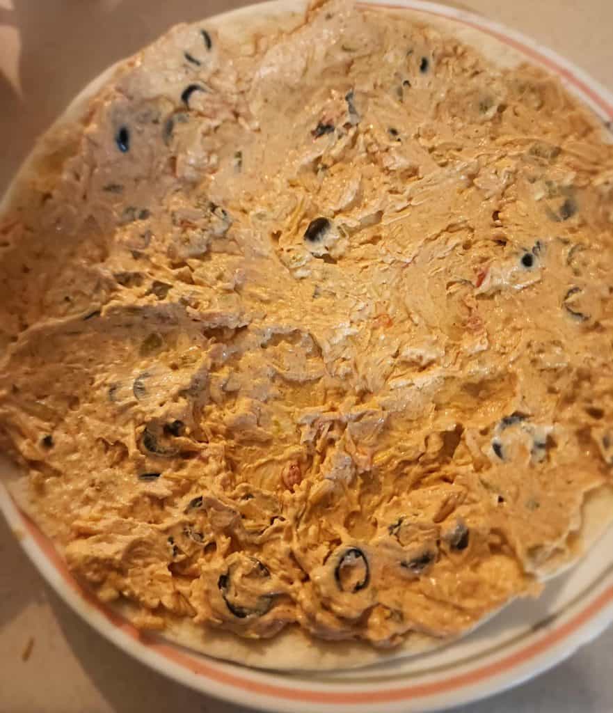 Filling spread on tortilla for Mexican roll ups