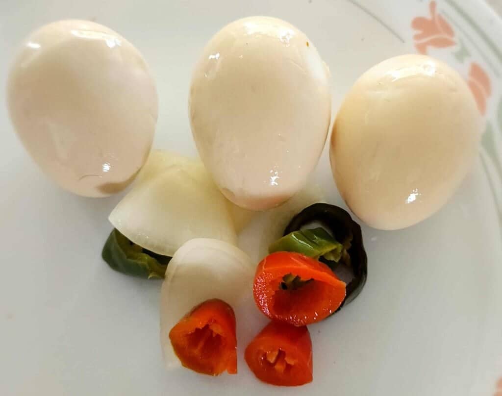 sweet and spicy pickled eggs with peppers and onions