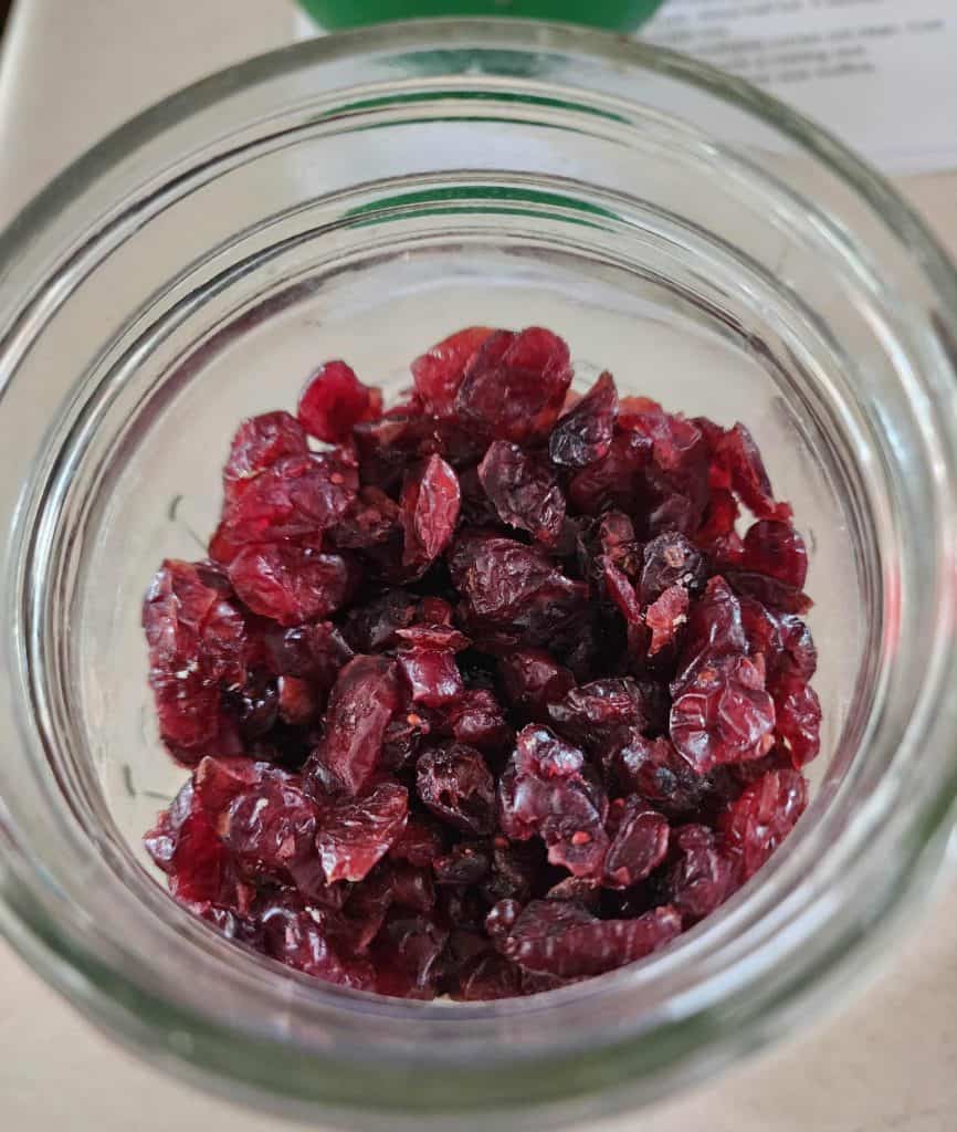 Dried cranberries from top of jar added to make Christmas Muffins in a jar