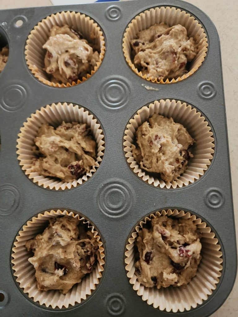 spooning muffin mix into jar