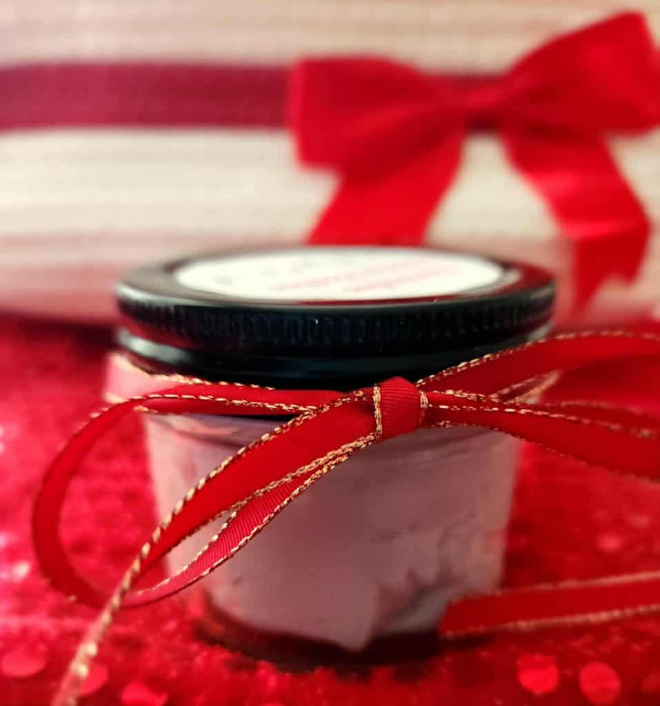 Christmas body butter with bow in front of basket