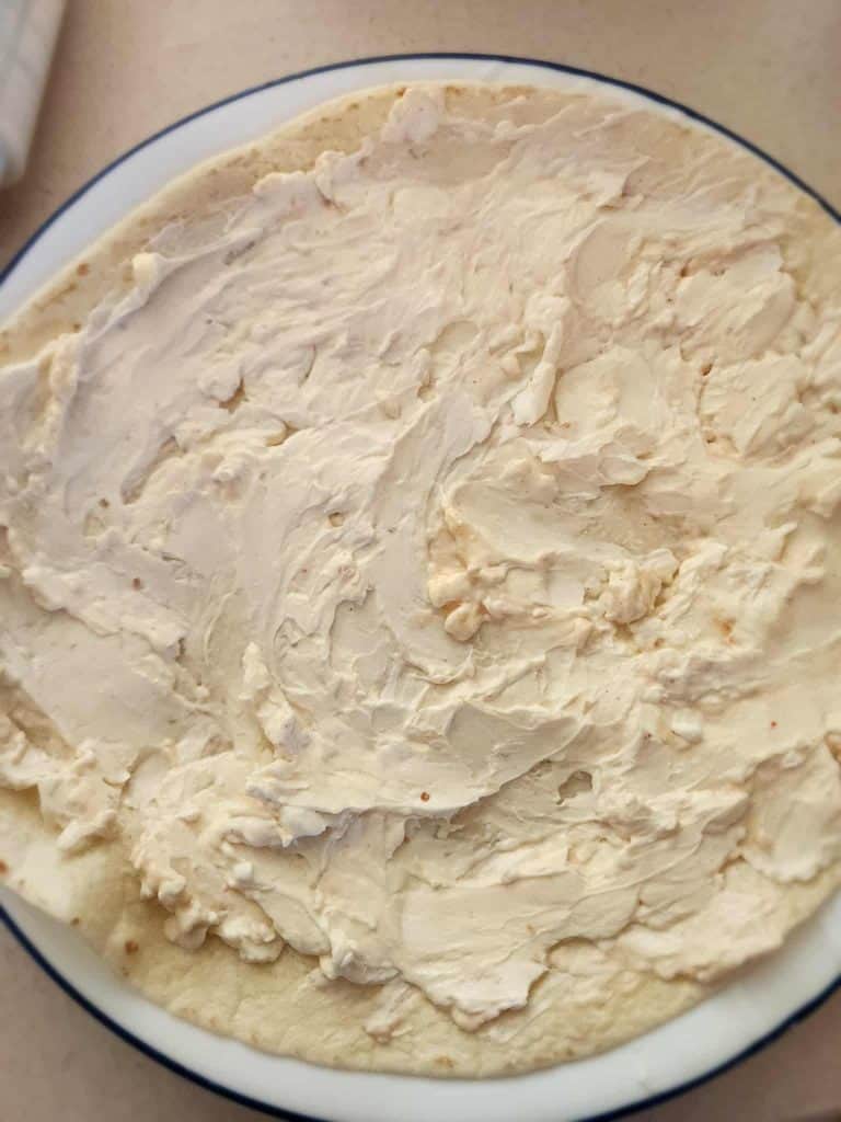 cream cheese and Italian dressing mixture spread on tortilla to make salami pickle roll ups