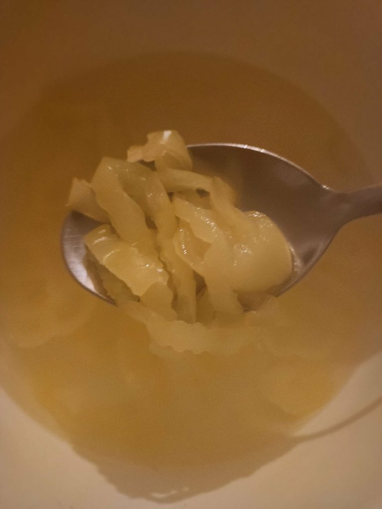 banana peppers in slotted spoon to layer with eggs for banana pepper pickled eggs