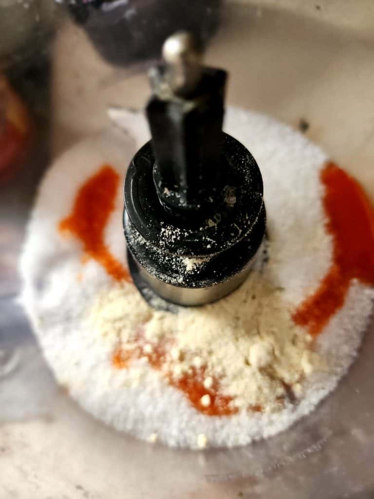Adding salt, buffalo sauce and ranch dressing mix to food processor to make buffalo ranch salt