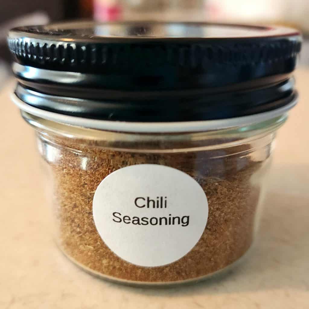 chili seasoning added to small jar with label