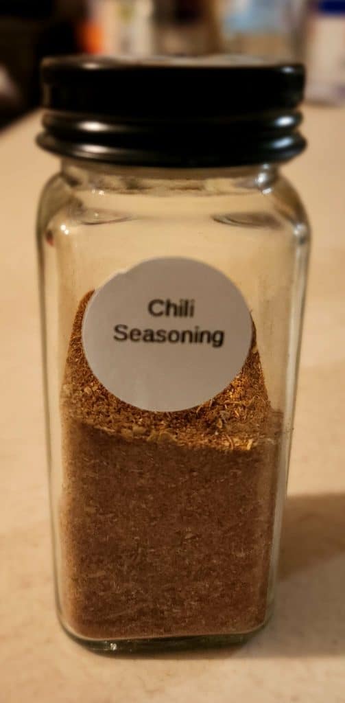 chili seasoning added to tall spice jar with label