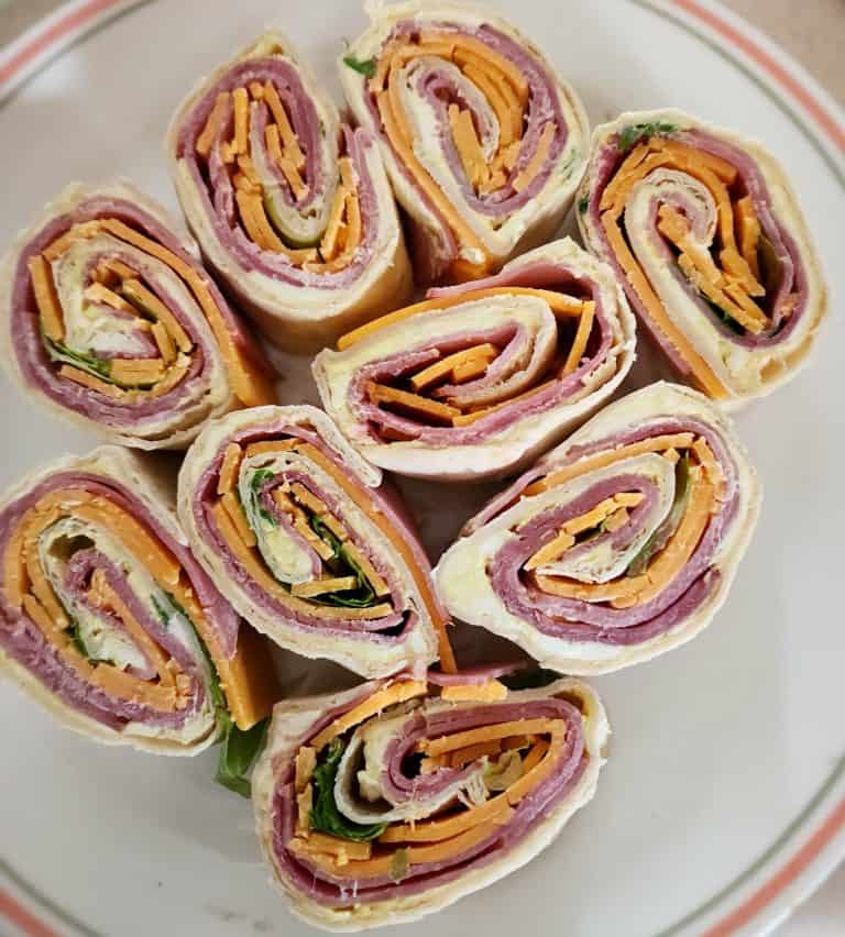 ham and cheese roll ups sliced and on a plate