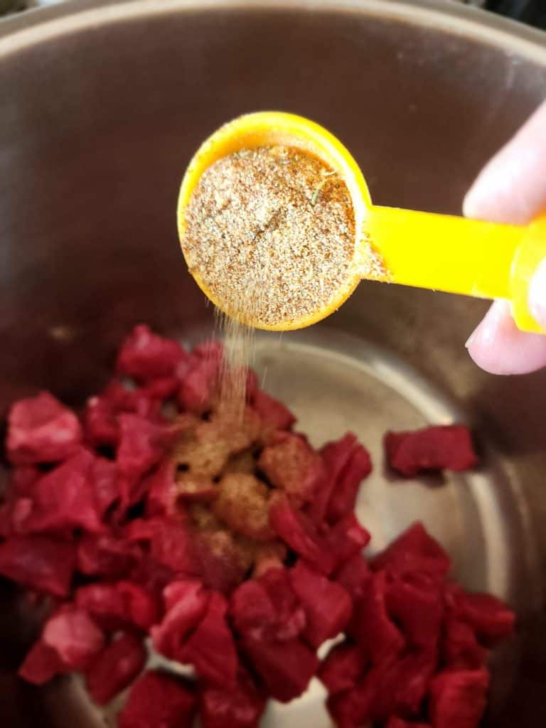 adding beef stew seasoning to the meat.