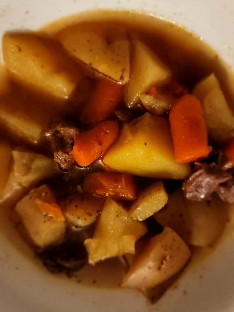 beef stew in a bowl seasoning with homemade beef stew seasoning