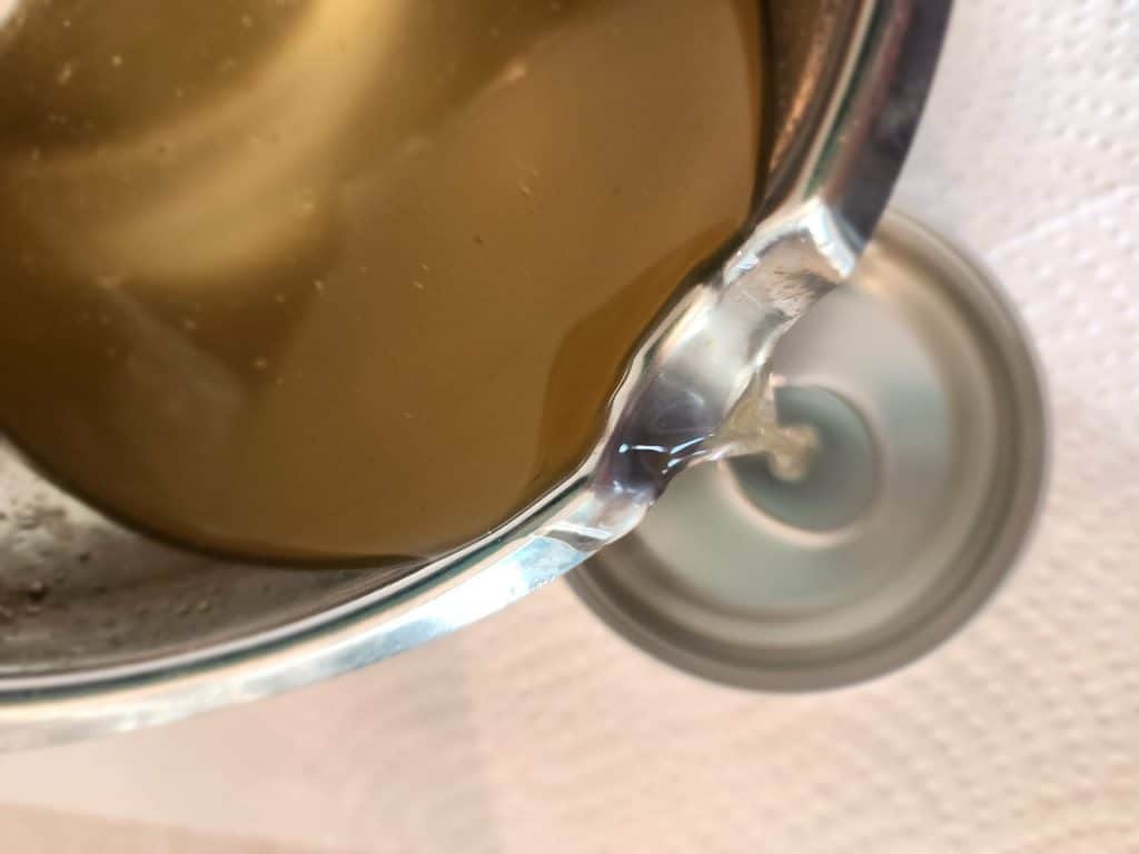 pouring liquid tallow balm into tin